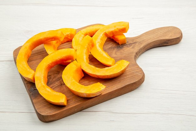 Bottom view chopped butternut squash on cutting board on white table