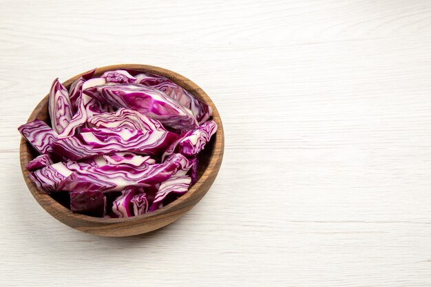 Bottom view chopped red cabbage in wooden bowl on white table free space