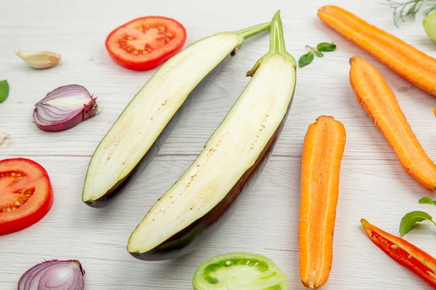 Bottom view chopped vegetables eggplant tomato carrot onion on grey wooden table