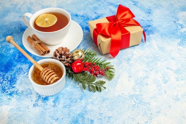 파란색 테이블 여유 공간에 있는 차 꿀 선물 크리스마스 트리 분기의 아래쪽 보기 컵