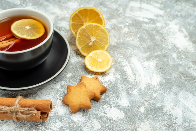 Bottom view a cup of tea lemon slices cinnamon sticks on grey surface copy place