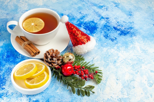 Bottom view cup of tea lemon slices santa hat on blue table