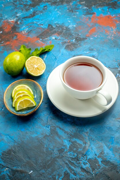 Bottom view a cup of tea with slices of lemon on blue red surface