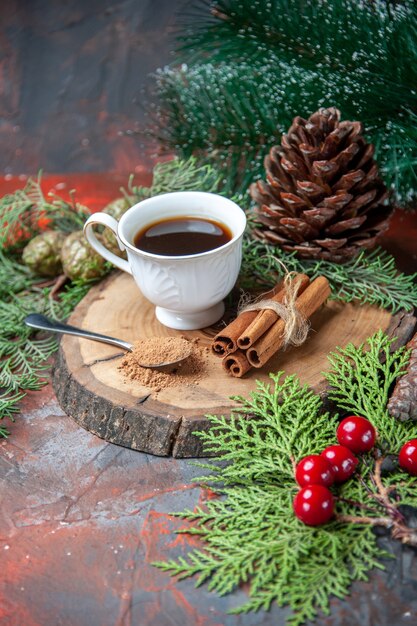 Bottom view a cup of tea on wood board cinnamon sticks pinecone on dark