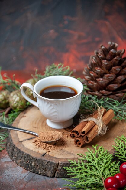 Bottom view a cup of tea on wood board cinnamon sticks pinecone on dark