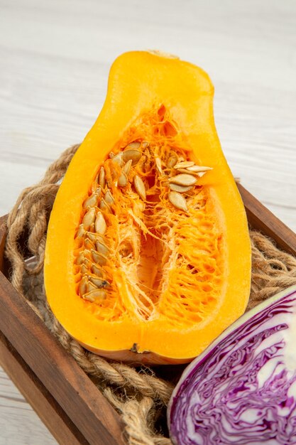 Bottom view cut butternut squash cut red cabbage in wooden box on grey table