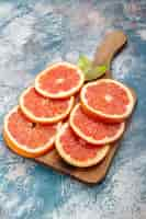 Free photo bottom view cut grapefruits on cutting board on blue white surface