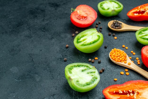 底面図カット野菜緑と赤のトマト赤ピーマン居心地の良い赤レンズ豆黒コショウを木のスプーンでテーブルの上に空きスペースあり