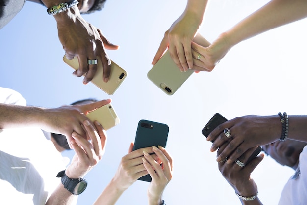 Free photo bottom view diverse group of friends with phones