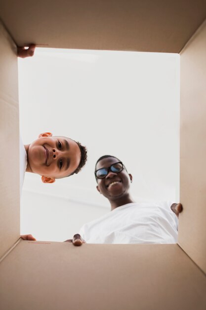 Bottom view father and son looking into a box