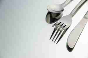 Free photo bottom view fork knife spoon on light surface with copy space