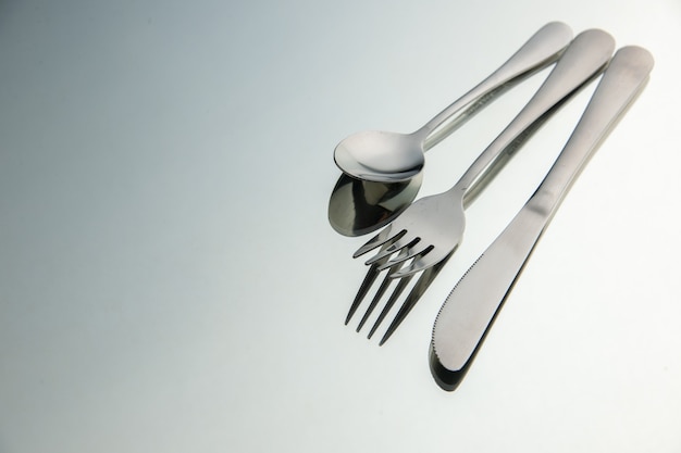 Bottom view fork knife spoon on mirror copy place