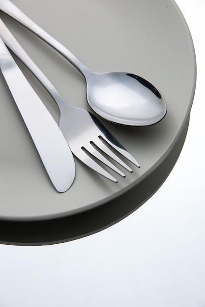 Вид снизу вилка, ложка, нож на тарелке на белой изолированной поверхности