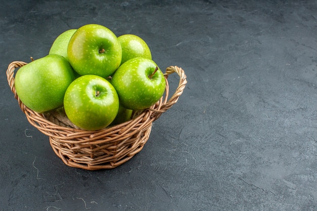 Bottom view fresh apples in wicker basket on dark surface with free space