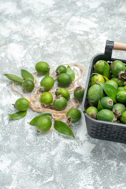 Free photo bottom view fresh feykhoas in basket on grey surface