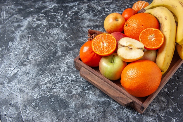 Bottom view fresh fruits and cinnamon sticks on wooden tray on table free space