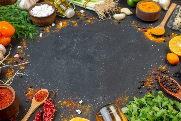 Bottom view fresh greens spices in small bowls and wooden spoons oil bottle on table with copy place