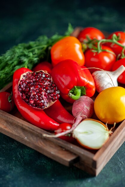 Bottom view fresh vegetables and half pomegranate on wood board on dark