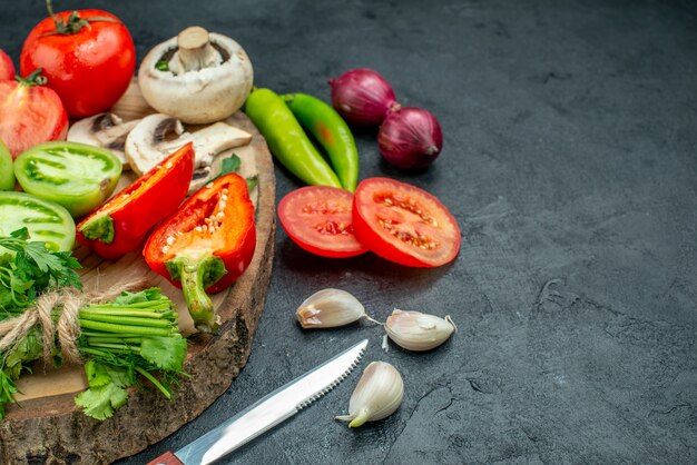 底面図新鮮な野菜のキノコ赤と緑のトマトピーマン緑の素朴なボード唐辛子ナイフニンニクの暗いテーブルの空きスペース