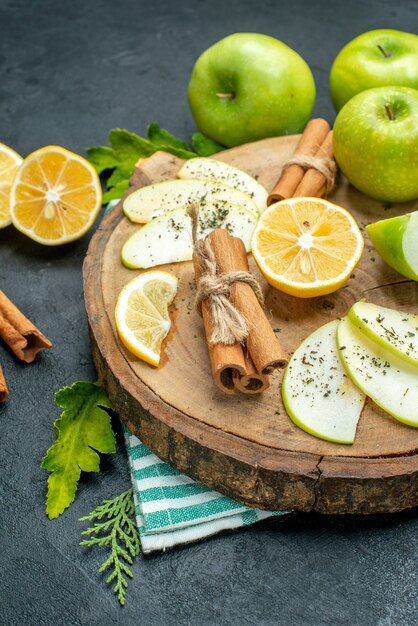 Bottom view green apples cinnamon sticks and lemon slices apple slices on wood board cut lemons apples on black table