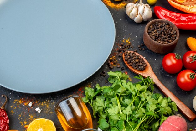 Bottom view grey round platter fresh vegetables and other stuffs on black table