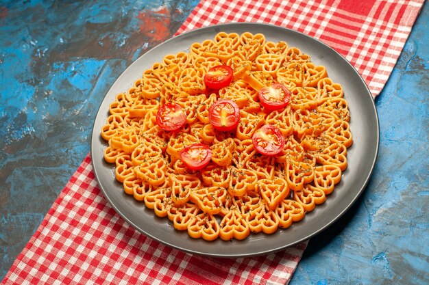 하단보기 이탈리아 파스타 하트 빨간색 흰색 체크 무늬 테이블에 타원형 접시에 토마토를 잘라