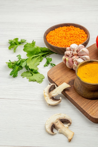 Bottom view lentile bowl garlic turmeric on chopping board mushrooms parsley on grey table