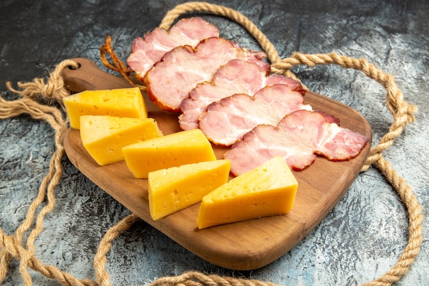 Bottom view meat slices cheese slices on chopping board on grey