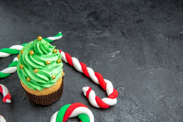 Bottom view mini xmas tree cupcake and xmas candies on dark background free space