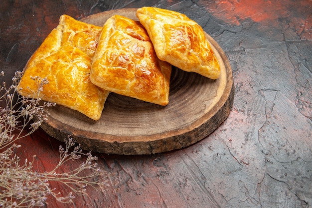 Bottom view penovani khachapuri on wood board dried flower branch on dark red table georgian cuisine