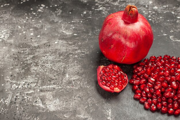 Free photo bottom view pomegranate pomegranate seeds on dark table with free space