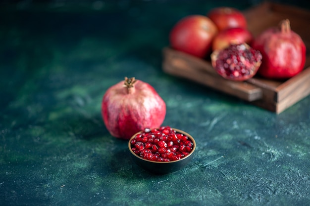 Bottom view pomegranate seeds bowl pomegranates on wood board on table