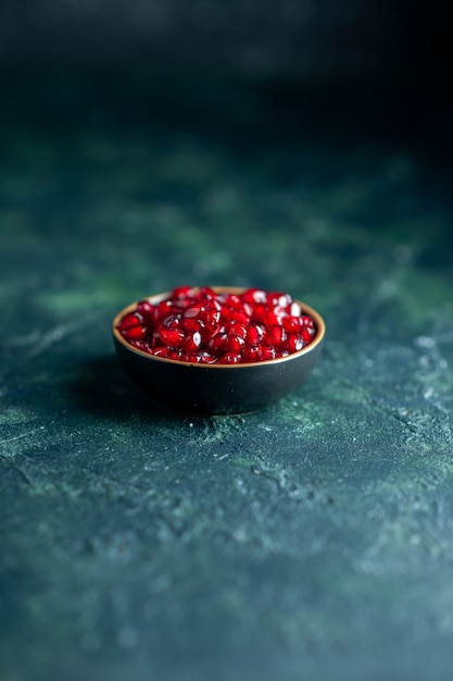 Free photo bottom view pomegrante seeds in small bowl on dark with free space