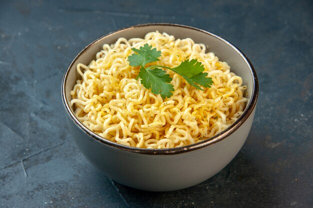 Bottom view ramen noodles with coriander in bowl on dark table