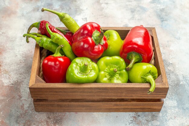Bottom view red and green peppers hot peppers in wooden box on nude background