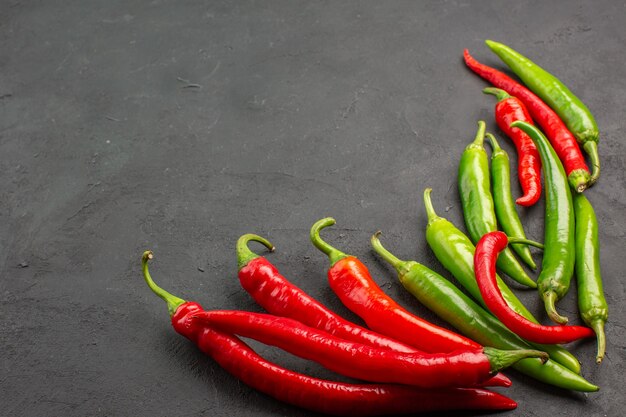 Bottom view red and green peppers at the right side of black table