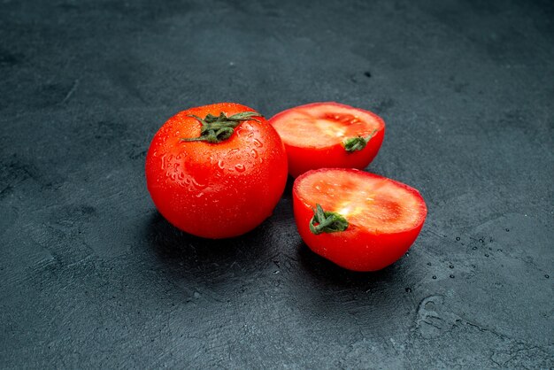 Bottom view red tomatoes cut in half on black table free space