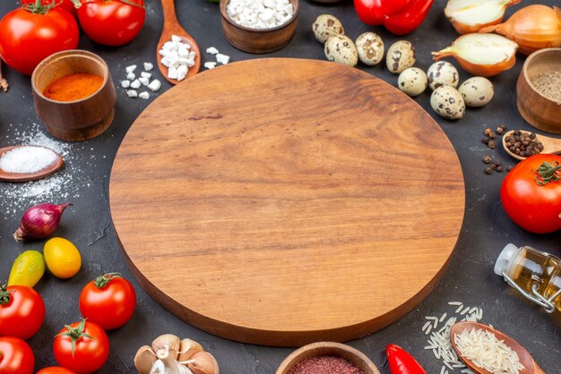 바닥 보기 둥근 나무 보드 cumcuats 바다 소금 그릇에 그리고 나무 숟가락 양파 토마토 어두운 테이블에