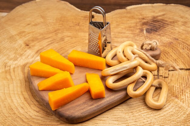 Bottom view slices of cheese box grater oval bagels on cutting board on wooden ground