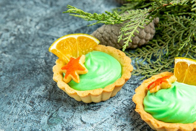 Bottom view small tart with green pastry cream pinecones on grey surface