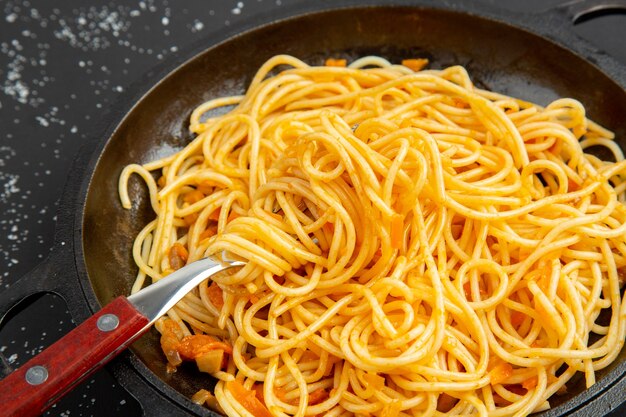 Bottom view spaghetti frying pan on black background