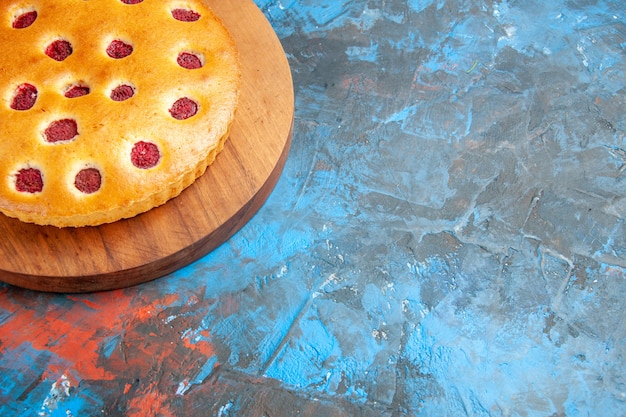 Bottom view strawberry cake on oval plate on blue table copy space