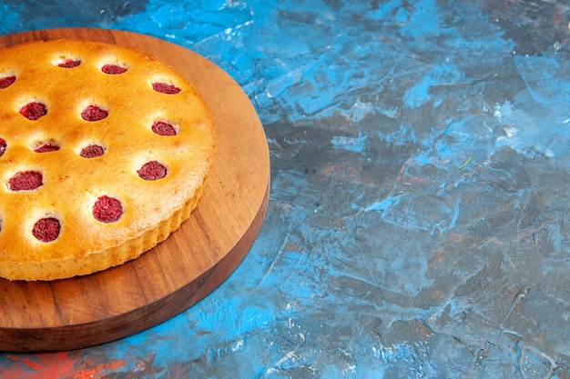 Free photo bottom view strawberry cake on oval plate on blue table free space