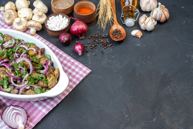 Bottom view tasty kebab bowl red onions spices in small bowls wooden spoon mushrooms on dark table copy place