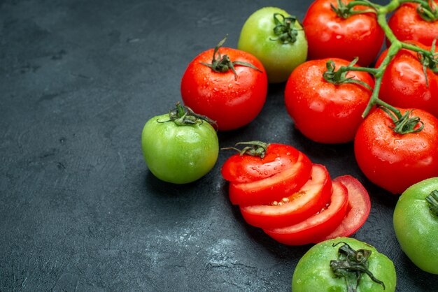 Bottom view tomato branch chopped tomatoes fresh green tomatoes on black table free place