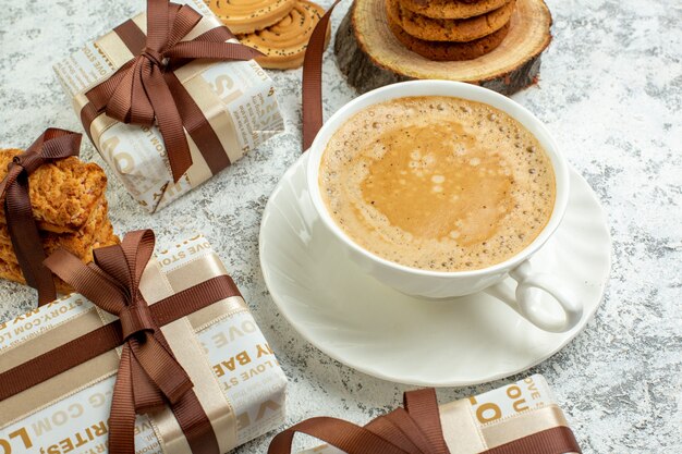 Bottom view valentines day gifts cookies tied with ribbon on wood board cup of coffee on grey wall