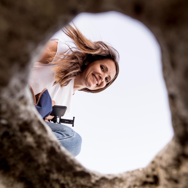 Free photo bottom view woman looking at a hole