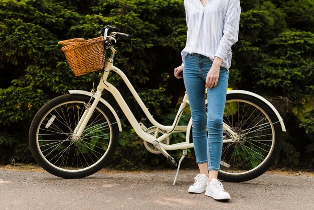 Bottom view woman posing next to bike