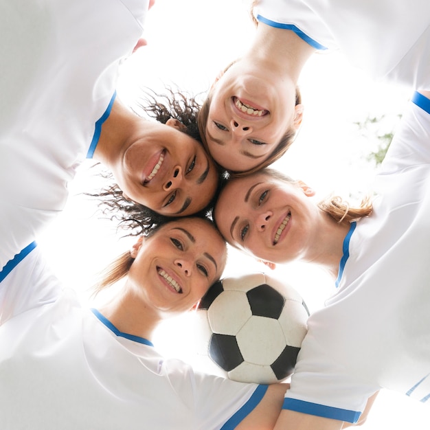 Free photo bottom view women holding ball close-up