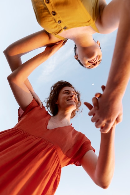 Bottom view women holding hands